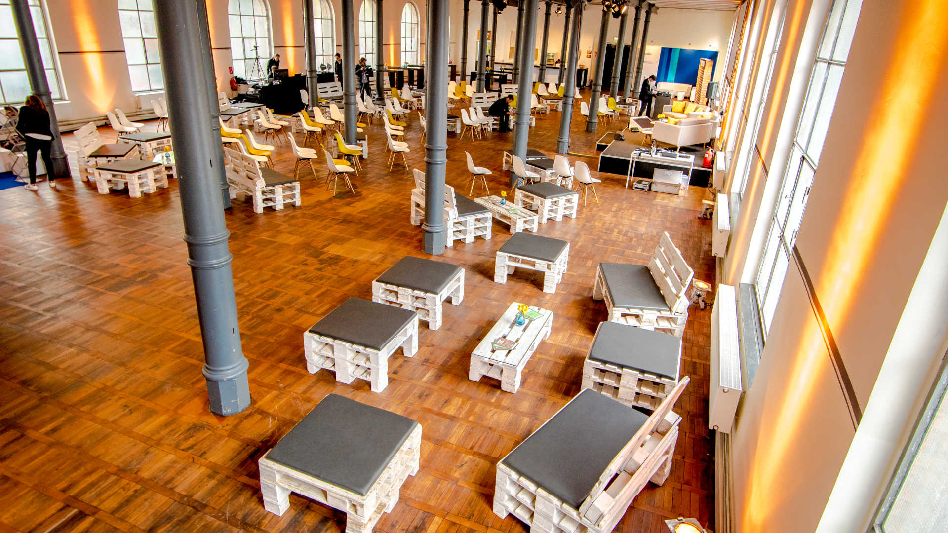 Große industrielle Eventlocation mit Konferenzsituation und Palettenmöbeln.