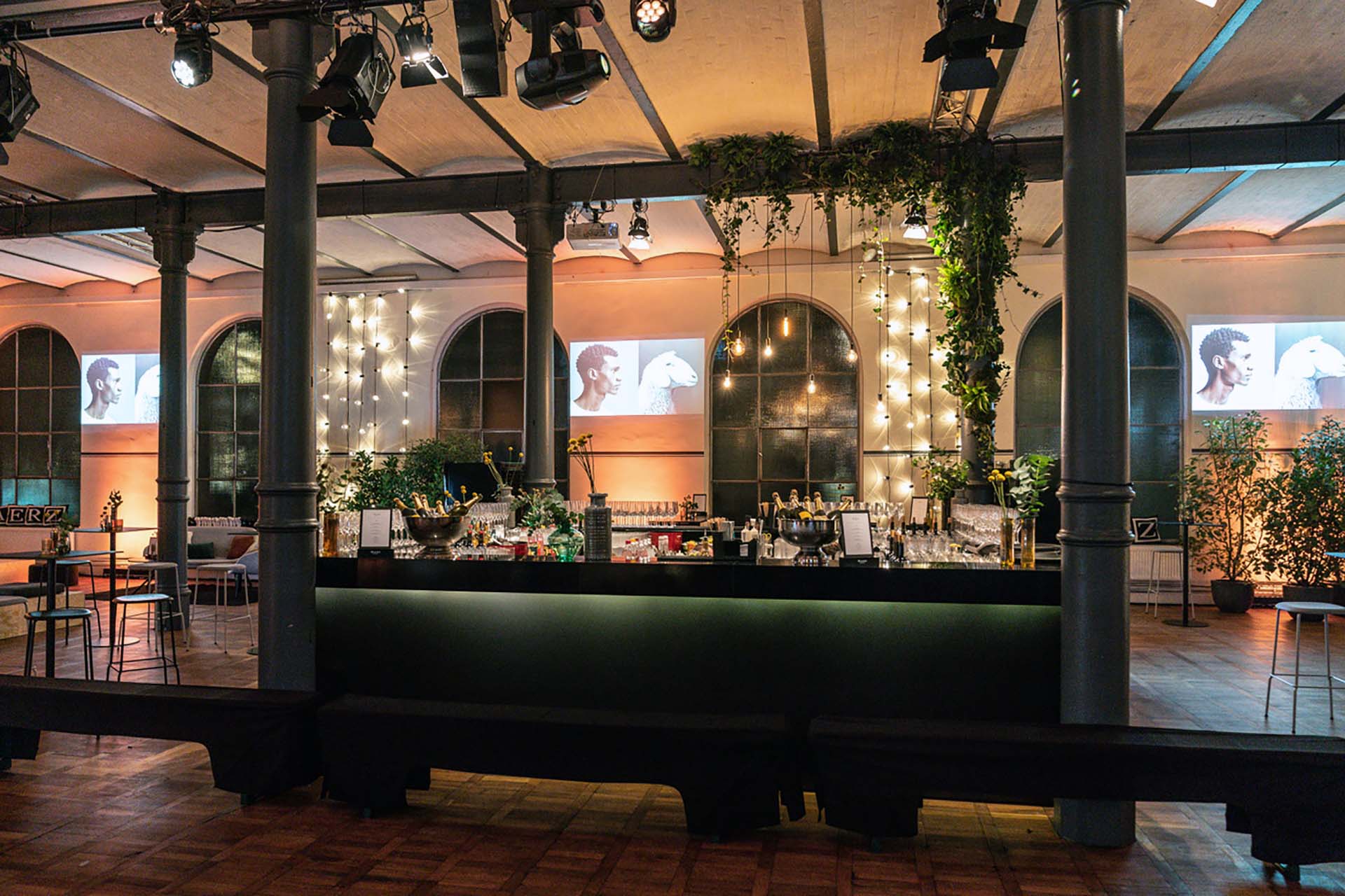 Event marketing agency Berlin – illuminated bar with string lights and plants for get-togethers at the Magazin in the Heeresbäckerei