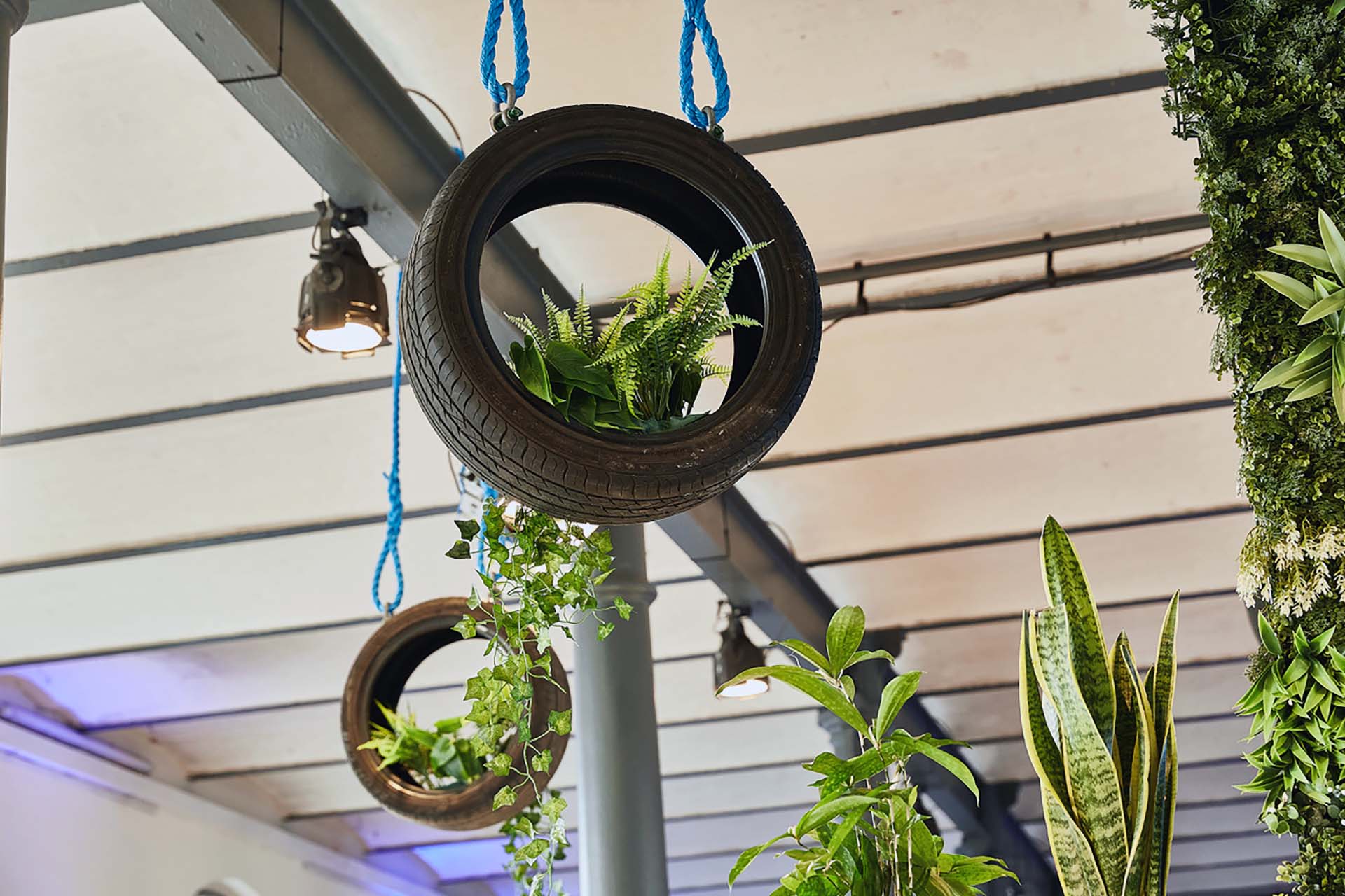 Marketing event agency Berlin – creative event decoration with hanging tyre planters and greenery at the Heeresbäckerei