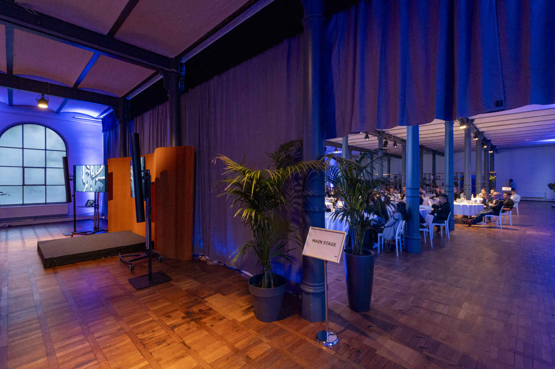 Großer Saal mit atmosphärischer Beleuchtung und Raumtrenner Stoffgardine