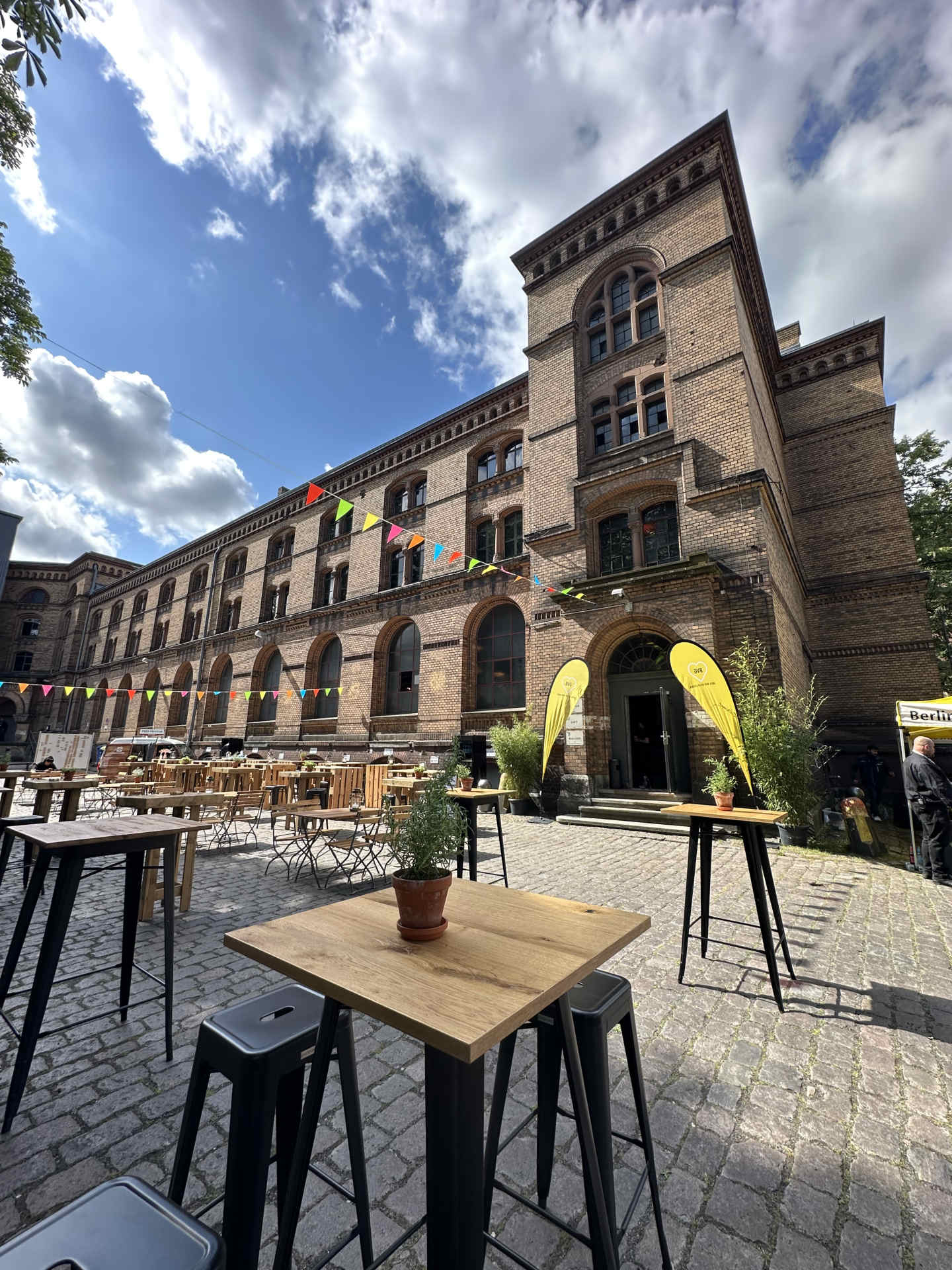 Außenbereich im Sommer mit Foodtrucks und Stehtischen und Wimpelkette