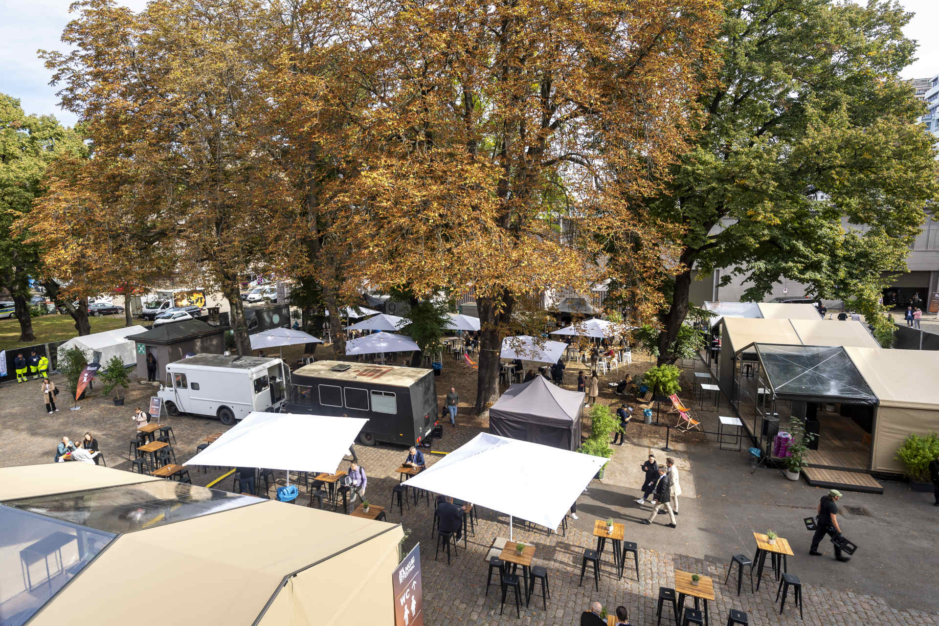View from above of the outdoor area in autumn with pavilions, food trucks and standing tables
