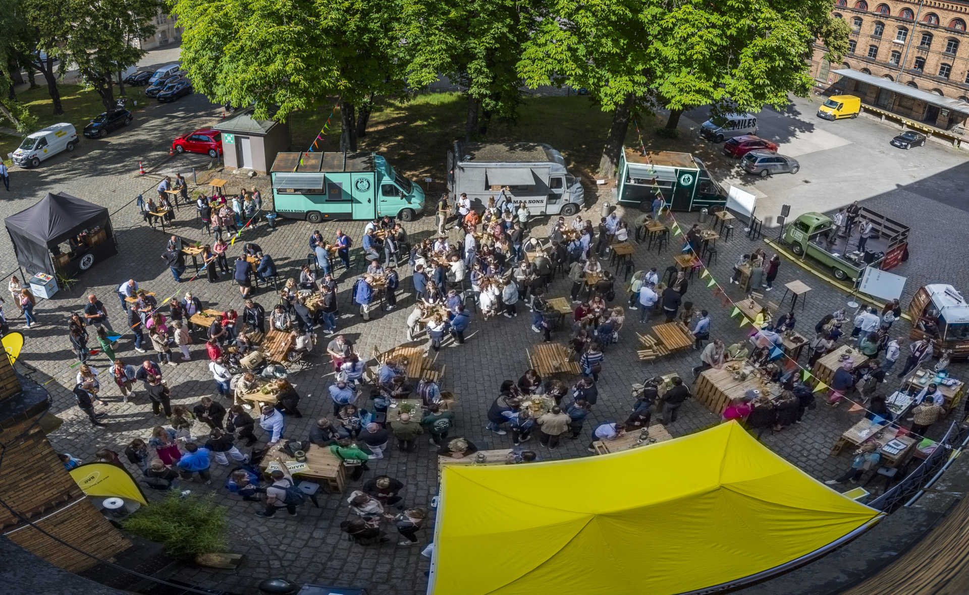 Vogelperspektive auf großen Hof mit vielen Menschen auf einem Sommerfest